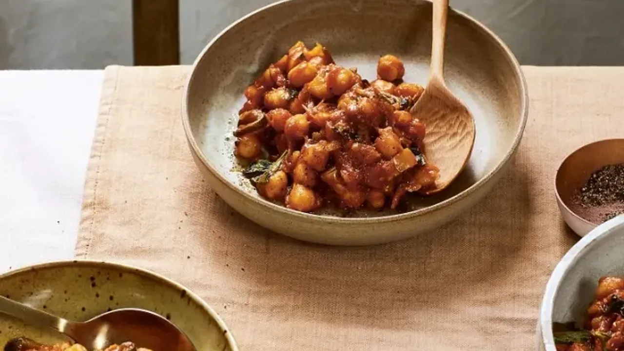Close up on a plate of mashed potatoes, topped with baked pork chops with cream of mushroom soup, and a side of green beans.