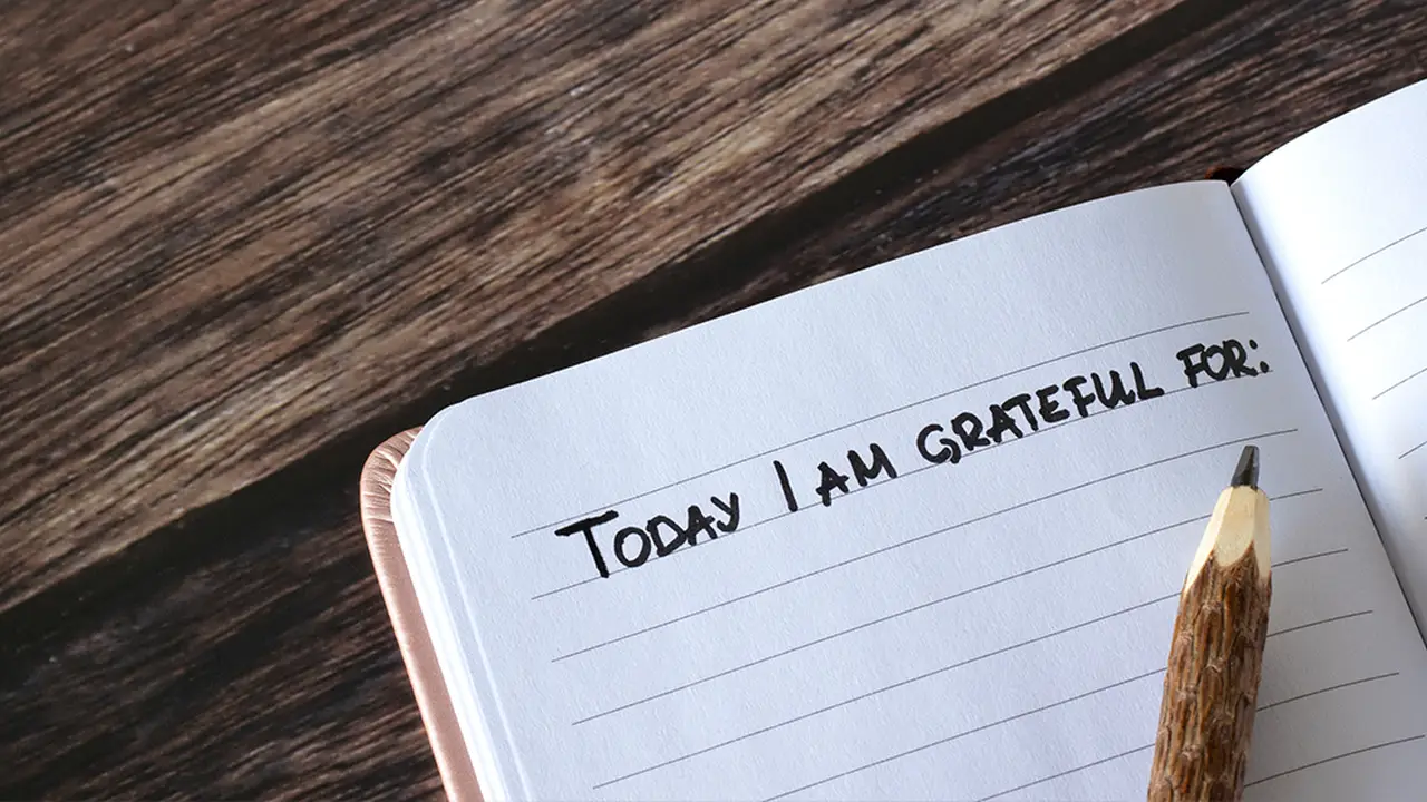 Close up on a plate of mashed potatoes, topped with baked pork chops with cream of mushroom soup, and a side of green beans.