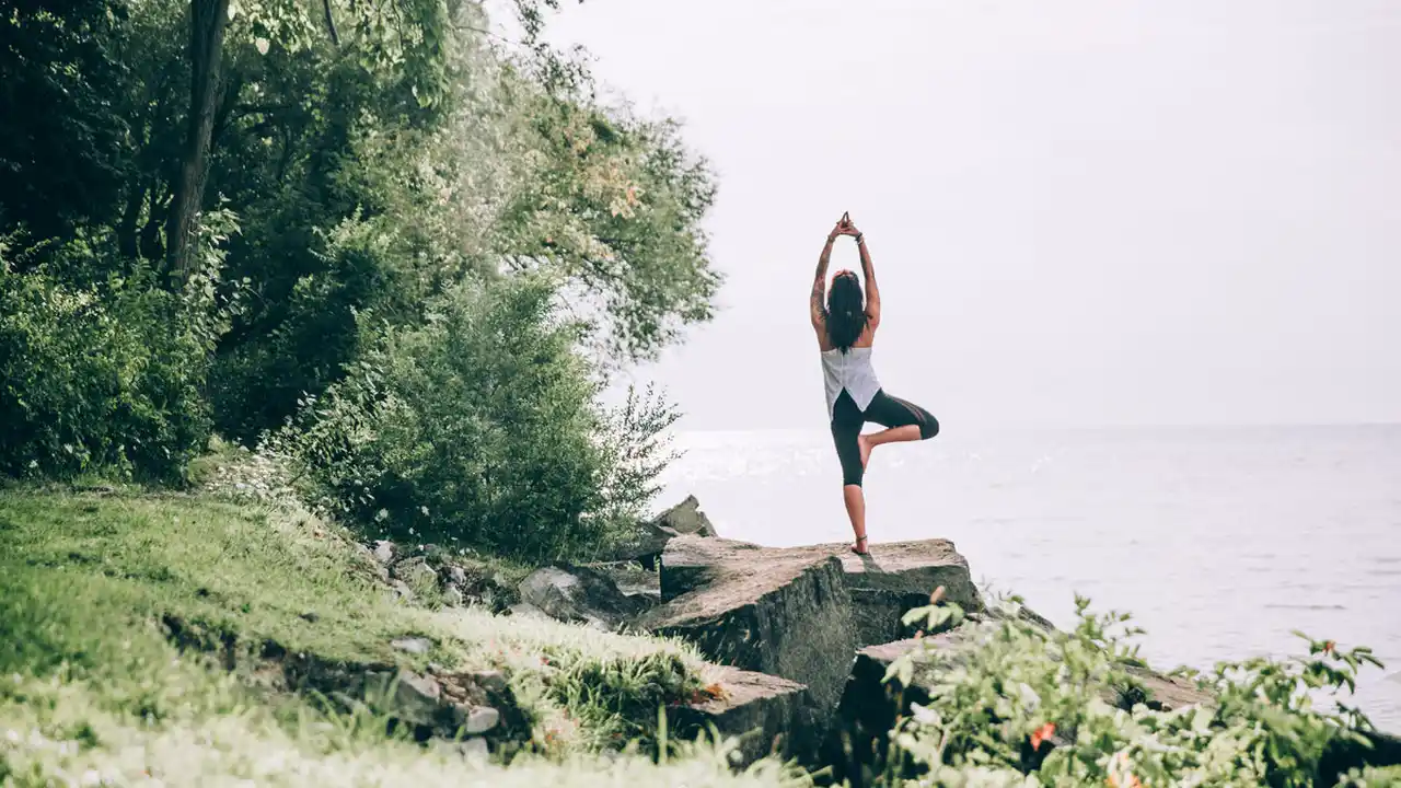 blue bowl of black bean beef tortilla soup on a board with cilantro and shredded cheese in background